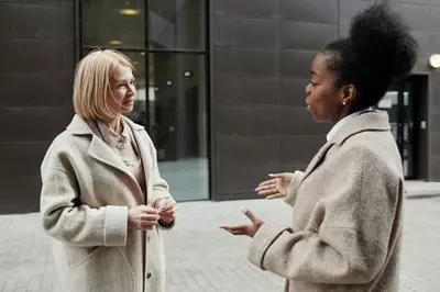 white woman listening to a Black woman