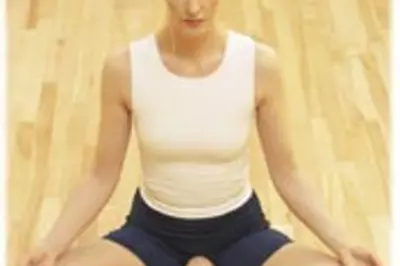 Seated woman meditating in yoga studio