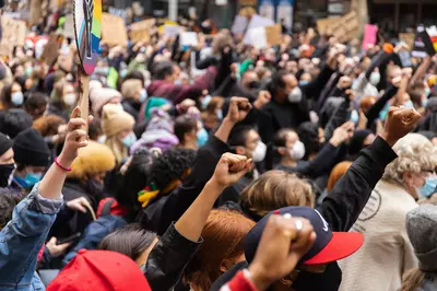 fists raised in solidarity at an outdoor protest