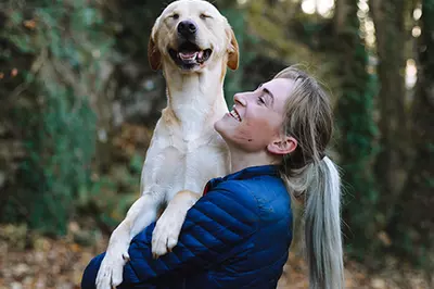 Blond woman holding blond dog