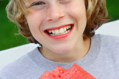 young boy smiling with watermelon