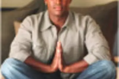 Man sits cross-legged on couch and meditates