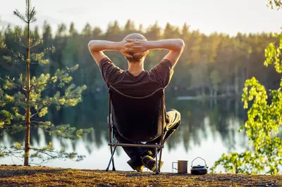 person relaxing by a lake