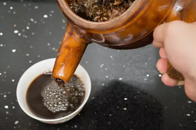 person pouring herbal tea