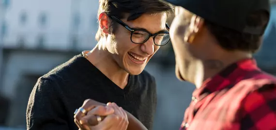 two friends smiling holding hands