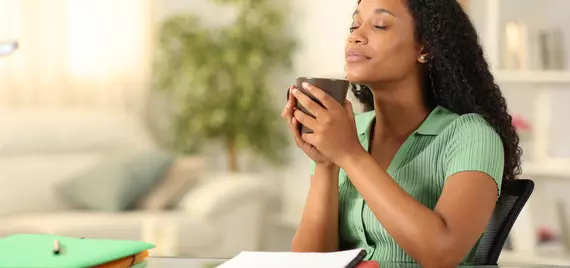 person with eyes closed holding a mug