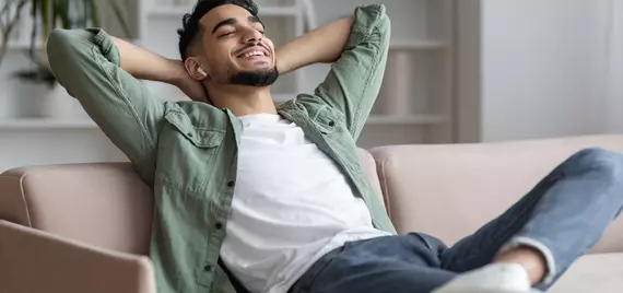 man relaxing on the couch with airpods