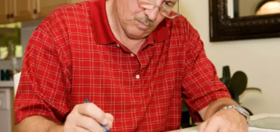 man looking stressed over paperwork