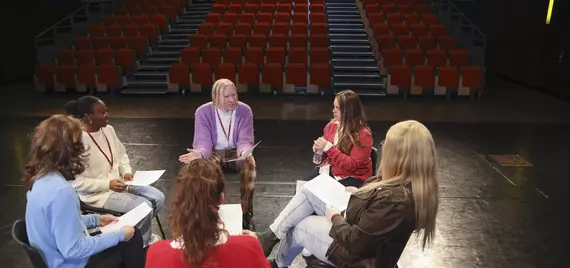 Actors reading through a script in a theatre