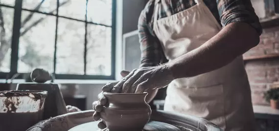 Man making a ceramic vase on a wheel