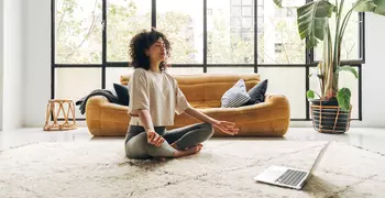 woman sitting in the lotus position in her living room