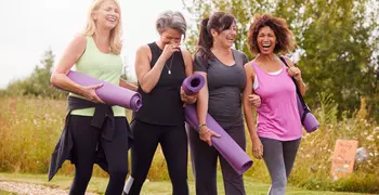 Group Of Mature Friends On Outdoor Yoga Retreat Walking Along Path