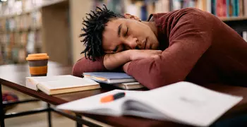 student sleeping in a library