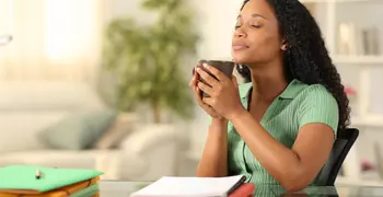 person with eyes closed holding a mug