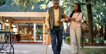 elderly man walking with his daughter