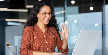 woman waving to someone on video chat