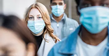 woman in a crowd wearing masks