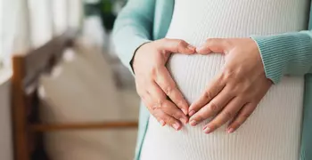 pregnant woman making a heart on her stomach