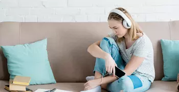girl sitting on couch listening to music