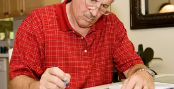 man looking stressed over paperwork