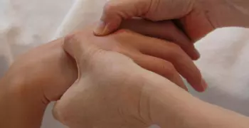 2 hands massaging one hand