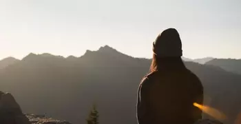 Woman sitting on top of mountain