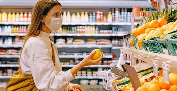 Person wearing a mask looking at produce.