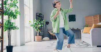Older woman dancing in a living room