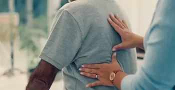 Doctor performing physical therapy for a person's back pain