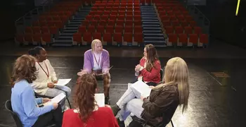 Actors reading through a script in a theatre