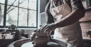 Man making a ceramic vase on a wheel