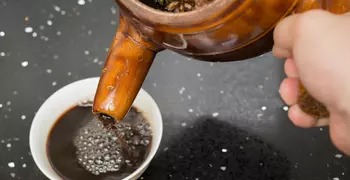 person pouring herbal tea