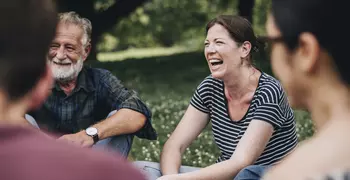 group of people laughing in a park