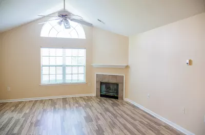 empty, airy room with large window and ceiling fan