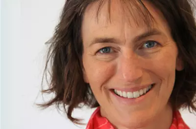 Barbara Fredrickson smiling at the camera against a white background