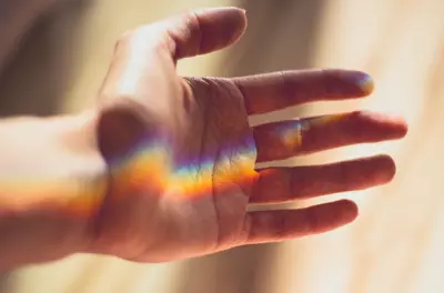 hand with rainbow light reflected
