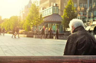 Person seated alone on a bench in an urban area