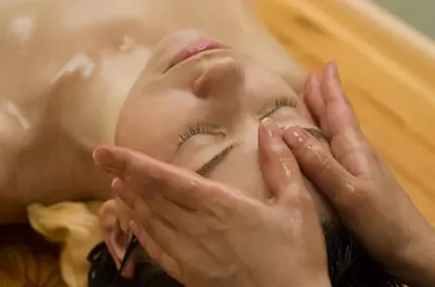 woman getting oil rubbed onto her forehead