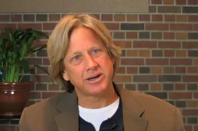 Dacher Keltner speaking in front of a brick wall