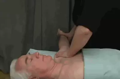 masseuse rubbing a client's arm as he lay on a table