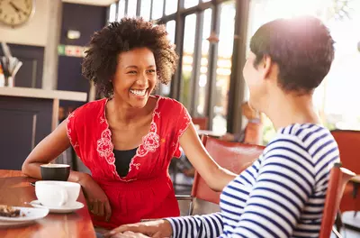 Two women happily talking in coffee shop