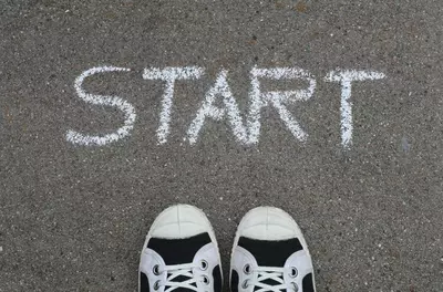 sneakers in front of start written in chalk on ground