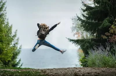 person doing a happy jump in nature