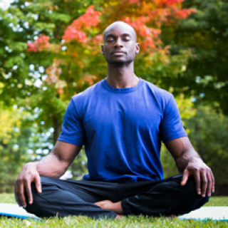 man sitting meditating outside