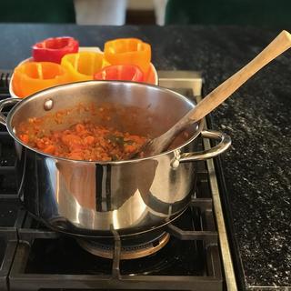 Bell peppers and a pot of filling on the stove.