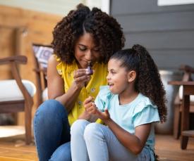 mother and daughter inhaling essential oils