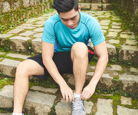 person tying shoes on steps