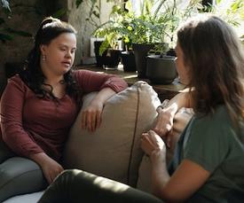 TWo women sitting on couch talking