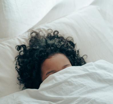 curly haired girl in bed