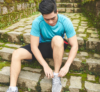 Person tying shoes on stairs